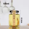 Atacado de fábrica criativo frasco de vidro hexagonal para mel caixa de espuma com tampa de ferro molho picante selado transparente lata de conserva de geleia