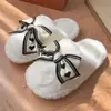 Nuevas y elegantes zapatillas de algodón con lazo para el hogar para mujer, cálidos zapatos de felpa para maternidad para invierno, adorable lana de cordero para todas las estaciones