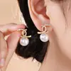 Nuevos Pendientes de Botón Estilo Francés Inspirados en Chanel con Letra Doble C Cruzada Perla y Diamantes, Ofreciendo una Estética de Moda de Lujo Ligero y de Alta Gama