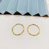 Venta al por mayor de Pendientes Redondos Transmitidos en Vivo con un Diseño Retorcido Pulido, Hechos de Cobre Chapado en Oro, Adecuados para el Uso Diario, de Estilo Sencillo