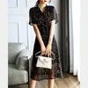 Vestido de Verão 2026 Novo Floral com Decote V de Manga Curta de Comprimento Médio para Mulheres com Design de Nicho e Elegante Vestido Retro com Ajuste na Cintura