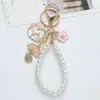 Llavero de coche con colgante de perla estilo coreano, llavero creativo estilo Chanel flor de cerezo, colgante de bolso con forma de corazón para niña, lindo