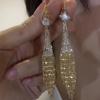 Una cortina de sueños, hermosos, brillantes, de moda, exquisitos, combinables con todo, con atmósfera de alta calidad, pendientes de cadena con borlas de trigo y hebillas para las orejas.