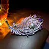 Broche Popular Transfronteiriço de Alta Resistência com Zircônia Roxa Degradê de Quilate Grande e Pena de Pavão com Pérola Design, Broche de Moda de Luxo Leve Atacado
