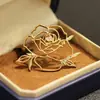 Temperamento Súper Simple Sentido de la Línea Hueco Plano Broche de Rosa Estilo Chanel Temperamento Flor Chapada en Oro Pin para Mujer
