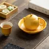 Juego de té de cerámica amarillo limón con detalles dorados, que incluye una taza con tapa, tetera, taza de maestro, taza de degustación, taza de té, soporte para tetera, posavasos y taza de equidad