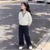 Conjunto de dos piezas de moda versátil para niñas para primavera y otoño con un top de diseño de dos piezas falsas y jeans estilo coreano