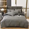 Venta al por mayor del fabricante Juego de cuatro piezas de color sólido de lujo ligero Rojo brillante Sábanas de cama bordadas para bodas Funda de edredón Algodón lavado Ropa de cama cepillada
