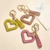 Nuevo llavero con forma de corazón hueco con diamantes, accesorio de arcilla totalmente cubierto de diamantes, decoración para bolso de mujer, colgante para interior de coche