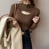 Top de capa base de diseño hueco de nicho para mujer nuevo otoño e invierno sensación de suéter de cuello alto moderno elegante top de punto