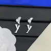 Pendientes de botón con letras y logo de marca de lujo europea y americana transfronteriza, versión de alta gama nueva, pendientes de trébol de cuatro hojas con aguja de plata para mujer, venta al por mayor