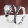 Conjunto de anéis de casal com caveira em estilo dark, duas peças, textura vintage e zircônias com quatro garras. Venda por atacado internacional.