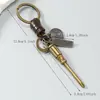 Llavero de metal vintage minimalista con colgante de cordón de cuero tejido, accesorio de llavero creativo unisex