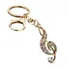 Llave de notas musicales creativas de lujo ligero europeo y americano Colgante pequeño Accesorios de joyería pequeños Rhinestone Metal Llavero para mochila Al por mayor