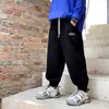 Calça Infantil 2026 Outono Nova Estilo Coreano Calça Esportiva Casual para Meninos com Estampa Única de Letras na Lateral para Crianças Maiores
