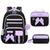 Nuevo juego de mochila escolar de tres piezas transfronteriza para estudiantes de primaria, mochila para niñas de gran capacidad con lazo, diseñada para reducir la carga, directo del fabricante
