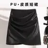 Saia preta popular de outono e inverno para mulheres, nova saia lápis de cintura alta emagrecedora de corte A, saia curta marrom de couro PU para mulheres de meia-idade e idosas