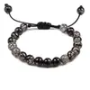 Este elegante brazalete presenta una combinación de ágatas marmoleados en blanco y negro que crean un diseño único y sofisticado. El cordón ajustable permite un ajuste cómodo, mientras que las distintivas cuentas con patrón de dragón le dan un toque extra. Un accesorio perfecto tanto para ocasiones casuales como formales.