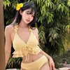 Bikini amarillo estilo vacacional con una sexy falda pareo, diseño de dos piezas, estilo de falda de alta gama, impresionante para la playa junto al mar
