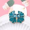 Una variedad de aretes de clip para oreja con forma de pétalo esmeralda cuadrado de color, flor de corazón con aguja de plata, aretes de flor azul verde oscuro