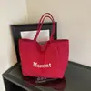 Bolso tote liso de estilo coreano, minimalista, con letras, que ofrece un ambiente relajado y casual, perfecto para estudiantes universitarios que van a clase temprano por la mañana.