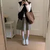 Foto real de la nueva moda coreana de alta gama para mujer de Dongdaemun, otoño 2026: chal simple, holgado, de color liso