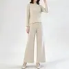 Conjunto plissado minimalista estilo japonês inspirado em Miyake, cor sólida com padrão sutil, top de manga longa com gola redonda, calça pantalona fluida, conjunto de duas peças casual para o outono