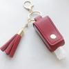 Una generación de funda de alcohol desinfectante con borla, funda para desinfectante de manos con llavero, funda portátil para desinfectante de manos