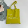 Bolsa de Lona com Estampa de Letras Nova Primavera Grande Capacidade Bolsa de Ombro Feminina Simples Fresca Versátil