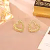 Pendientes de botón irregulares de corazón hueco Diseño de nicho Pendientes de aguja de plata S925 Pendientes de metal de moda simples y minimalistas