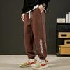 Pantalones deportivos casuales de otoño e invierno, nuevos pantalones holgados de estilo Hong Kong con costuras versátiles y estampados a la moda para parejas, con cintura elástica y tobillos atados.