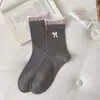 Calcetines de otoño e invierno estilo japonés con lazo floral hasta la mitad de la pantorrilla, calcetines holgados de tela a rayas dulces y modernos para mujer, venta al por mayor de la industria del calcetín de Zhuji