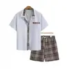 Conjunto de dos piezas de camisa de manga corta para hombre talla grande y shorts a cuadros transfronterizo, traje casual oversized europeo y americano, venta al por mayor del fabricante