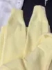 Suéter cárdigan de punto largo de estilo coreano moderno, suave y cómodo, en color amarillo cremoso y con botones dorados, perfecto como prenda exterior para mujer en otoño e invierno.