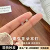 Aretes de tornillo de flor pequeña hueca de plata 999 para el cuidado de perforaciones, aretes elegantes y sofisticados, aretes de diseño de nicho para mujer