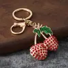 Directo del fabricante, nuevo y creativo llavero de cereza con artesanía de goteo de aceite, colgante de fruta de metal con diamantes de imitación con un toque de alta gama