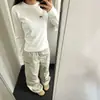 Camiseta blanca de manga larga con hombros normales, muy bonita, para mujer, nueva de otoño e invierno 2026, estilo americano fresco y atrevido, corte ajustado, favorecedora, top interior