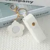 Mini llavero de lipstick portátil, bolsa redonda de cuero con espejo de maquillaje, accesorio para niñas, colgante de bolsa de espejo de maquillaje portátil