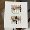 Un precioso juego de uñas postizas retro con corazón tallado chapado en oro negro y ojo de gato en polvo de oro