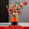 Peças decorativas com tema de caqui para 2026, criando uma atmosfera festiva para uma inauguração de casa, com flores artificiais criativas para exibição no rack da TV da sala