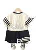 Conjunto de ropa de verano para bebé, ropa nueva y elegante para niños, conjunto de dos piezas de verano para niños 2026 con bolso de hombro y manga corta, al por mayor de moda