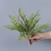 Plantas verdes artificiales en stock, manojos de helecho, hojas de helecho, hierba de helecho para decoración de paredes interiores y diseño de paisajes, césped artificial al por mayor