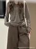 Chamarra fina de punto con capucha color castaño para mujer, colección primavera/otoño 2026, con corte relajado y holgado, cuello semiabierto y una base de tipo Henley