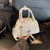 Bolsa de boliche de nicho de comercio exterior para mujer, nuevo bolso de mano pequeño de moda 2026, diseño casual versátil, bolso de hombro y bandolera