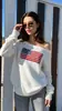 Site independente primavera e outono desejo feminino europeu e americano top branco com padrão, suéter de tricô versátil de ombro único solto atacado moderno