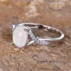 Anillo ovalado de ópalo más vendido transfronterizo, con un diseño de banda retorcida y detalles de ópalo engastados con diamantes.