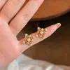 Brincos estilo vintage, duradouros e versáteis, apresentando um design único com um padrão de grama dourada torcida e detalhes de trevo de quatro folhas, adornados com pequenos cristais.
