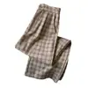 Toma real de pantalones largos casuales para mujer en un estilo relajado, con un patrón de cuadros retro color café, corte holgado, efecto adelgazante, diseño de pierna ancha y corte recto, para la colección de otoño 2026