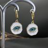 Moda europeia e americana simples olhos azuis de demônio redondo marca aço titânio fecho de orelha temperamento popular gota de óleo dourada brincos criativos mulheres