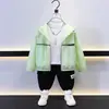 Roupa Infantil de Verão para Proteção Solar 2025 Novo Casaco com Capuz de Cor Sólida Estilo Coreano para Meninos Estilo Fashion Versátil Top Fino Leve Moderno